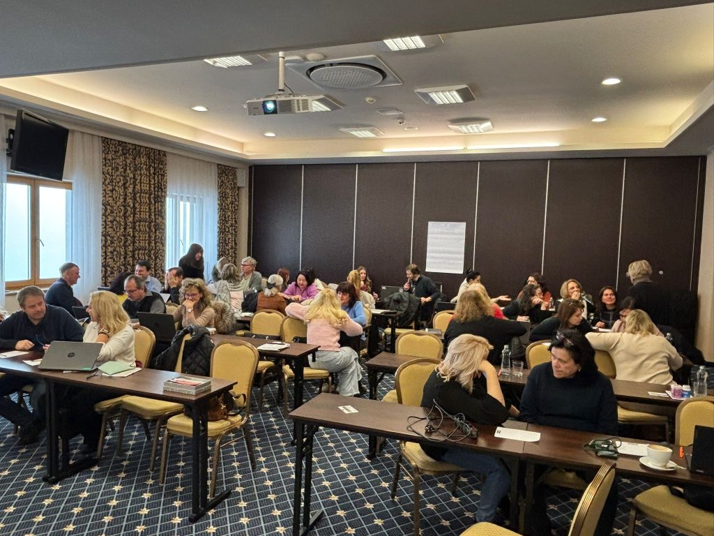 Lektori a lektorky sa vzdelávajú spoločne sedia za stolmi a diskutujú.